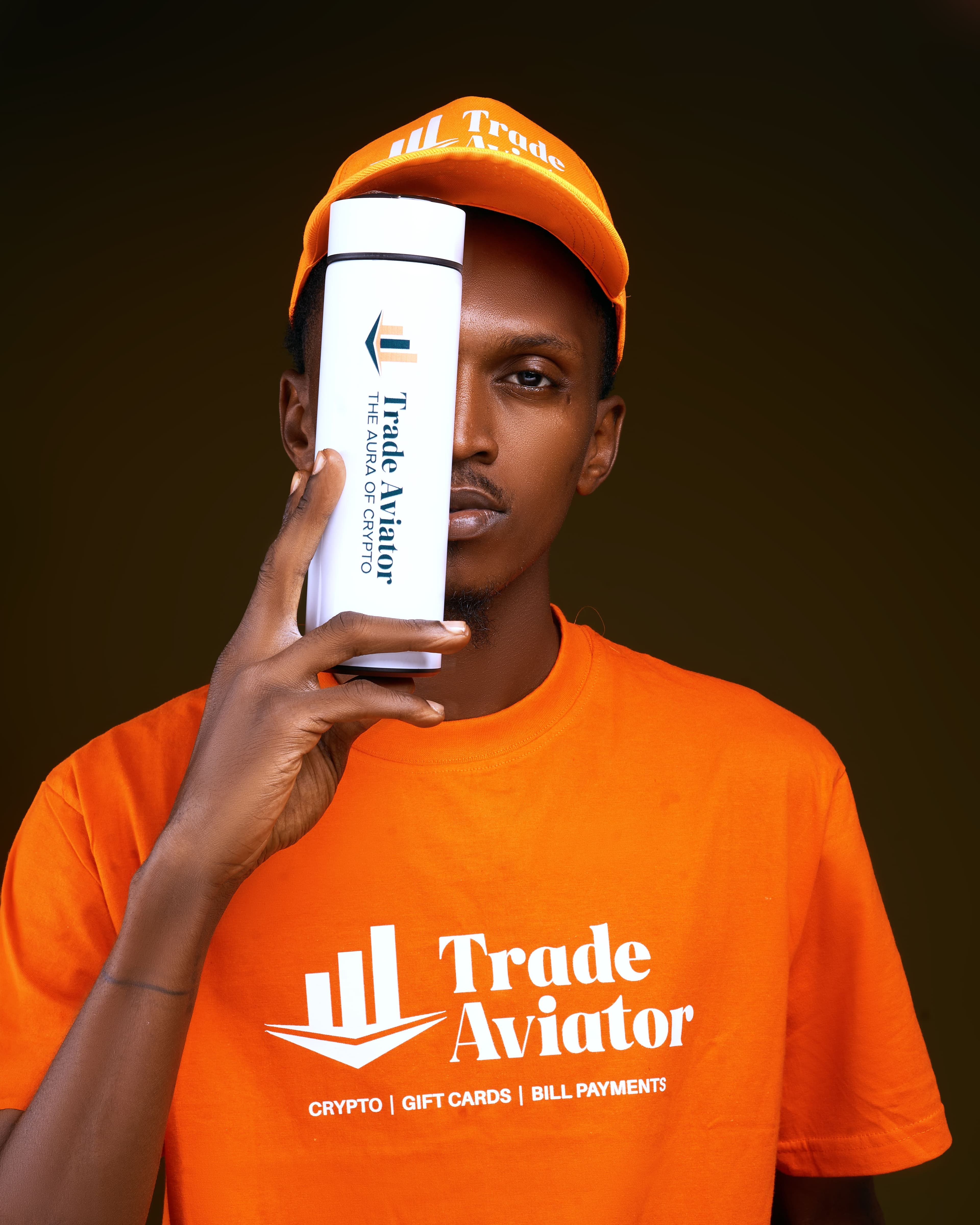 Toks, TradeAviator's official Brand Ambassador, holding a branded TradeAviator flask